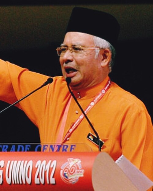 Najib ketika Perhimpunan Agung Umno 2012. Zaman Najib ditandai tekanan fiskal, pemberian tunai, GST, 1MDB dan percubaan terakhir Barisan Nasional mempertahankan susunan lama.