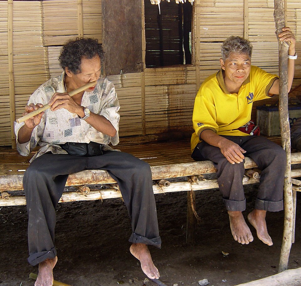 Seorang Orang Asli bermain seruling hidung di Malaysia. Rencana ini tidak menulis Orang Asli semata-mata sebagai mangsa; mereka mempunyai muzik, bahasa, nama tempat, ingatan tanah, dan tuntutan politik mereka sendiri. Penggerekan hamba hanyalah satu bab gelap yang perlu diakui, bukan keseluruhan identiti mereka.